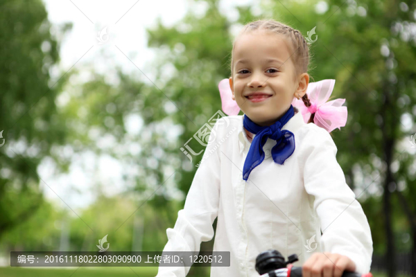 在绿色公园里骑自行车的女孩