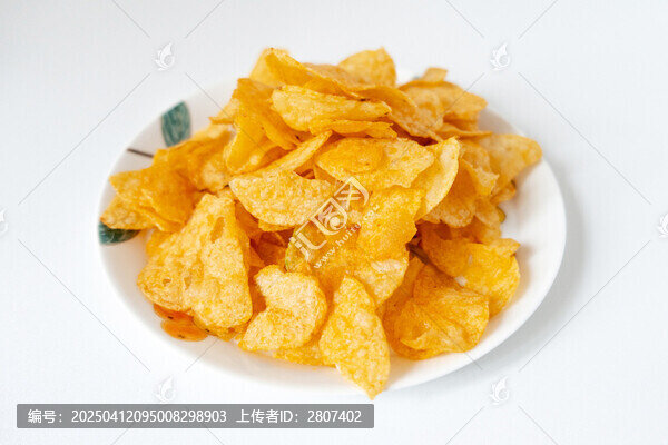 一盘白色彩绘碟子里装着一堆膨化薯片零食